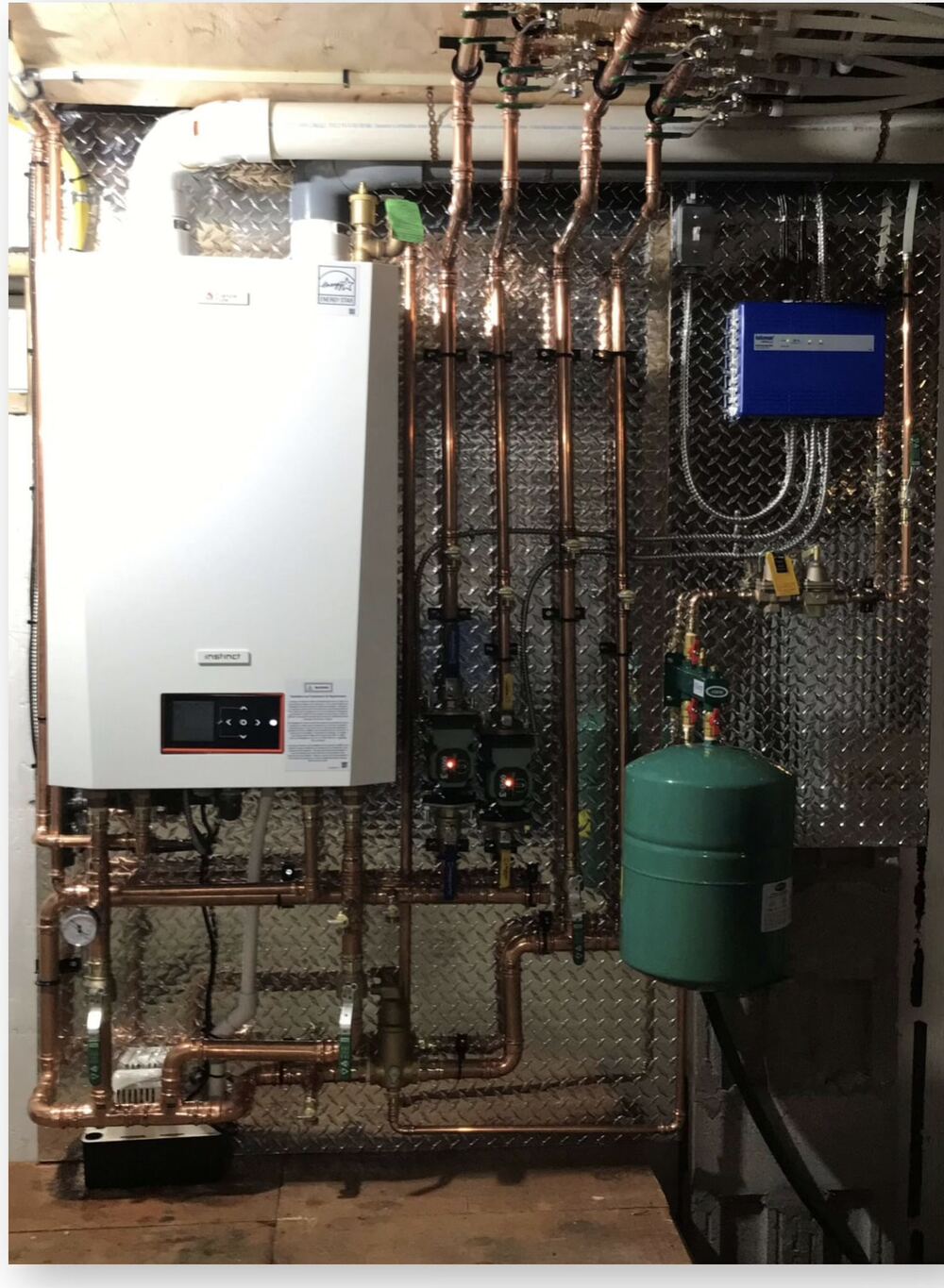 Wall-mounted hydronic boiler with copper piping pumps expansion tank and zone controls